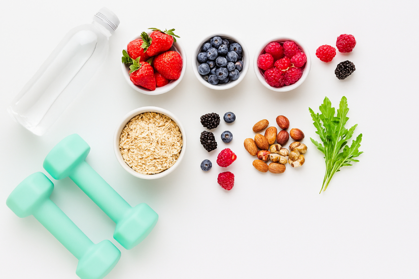 Fitness Nutrition concept: flat-lay of berries, oats, nuts, greens, water bottle, and dumbbells on a clean background